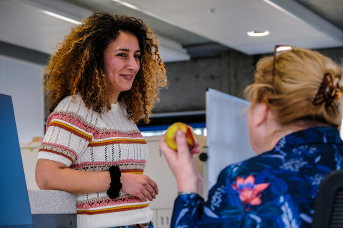 Twee medewerkers voeren een gesprek